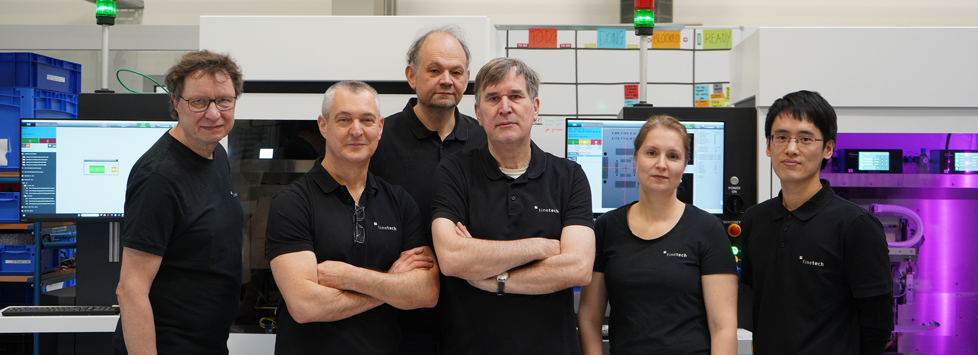 Service team smiling in front of Femto family automated die bonder machines